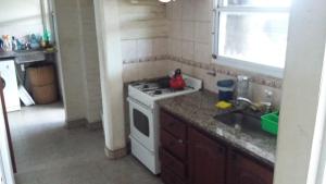 eine Küche mit weißem Herd und Spüle in der Unterkunft La Palmera escondida in Colón