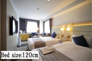 Säng eller sängar i ett rum på Hotel Sunroute Stellar Ueno