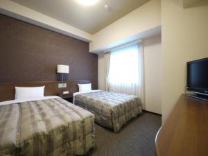 
A bed or beds in a room at Hotel Route-Inn Fukui Ekimae
