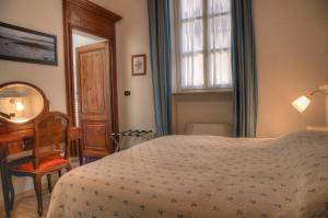 a bedroom with a bed and a desk and a mirror at Domus Aurea in Saluzzo