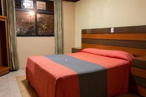 een slaapkamer met een bed met een rode en grijze deken bij Hotel H - Fabiola Adults Only in Mexico-Stad