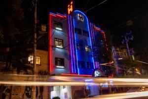 a building is lit up in blue and red at Hotel H - Fabiola Adults Only in Mexico City