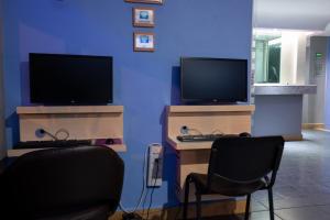 twee computermonitors en twee stoelen in een kamer bij Hotel H - Fabiola Adults Only in Mexico-Stad +8 foto's