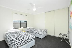 a bedroom with two beds and a window at Bayside in Aldinga Beach