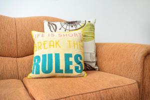 a pillow that says break the rules on a couch at Bayside - Aldinga Beach - C21 SouthCoast Holidays in Aldinga Beach