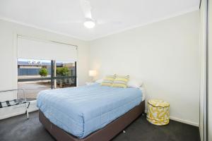 a bedroom with a large bed and a large window at Bayside in Aldinga Beach