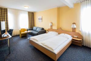 um quarto de hotel com uma cama grande e uma cadeira em Central Hotel em Mannheim