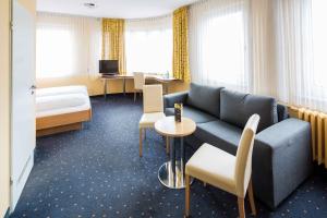 a hotel room with a couch and a bed at Central Hotel in Mannheim