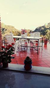 um pátio com uma mesa, cadeiras e vasos de plantas em Villa Sarino em Savoca