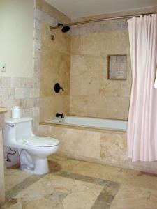 a bathroom with a toilet and a bath tub at Hotel Gran Mediterraneo in San Pedro Sula