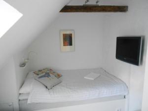 a small bedroom with a bed and a tv at Townhouse Lund in Lund