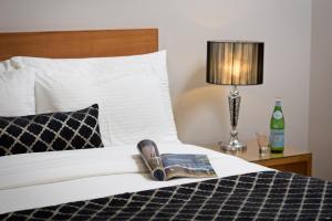 une chambre d'hôtel avec un lit et un livre dans l'établissement Ringwood Royale, à Ringwood