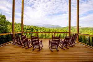 un grupo de sillas sentadas en una terraza de madera en Foxwood Mansion Cabin, en Pittman Center