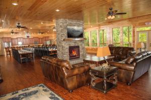 Una sala de estar con muebles de cuero y chimenea. en Foxwood Mansion Cabin, en Pittman Center 32 fotos más