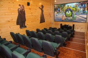 an auditorium with green chairs and a large picture of a movie at Foxwood Mansion Cabin in Pittman Center