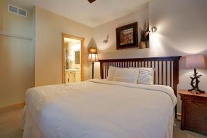 a bedroom with a large white bed with a wooden headboard at Mount Meeker 26B Condo in Estes Park