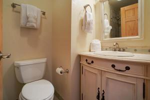 W łazience znajduje się toaleta, umywalka i lustro. w obiekcie Mount Meeker 26B Condo w mieście Estes Park
