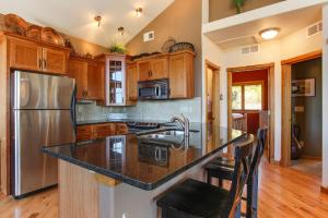 una cucina con frigorifero in acciaio inossidabile e mobili in legno di The Twin Owls 21A Condo a Estes Park