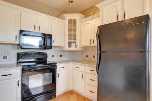 kuchnia z białymi szafkami i czarną lodówką w obiekcie Sheep Mountain 20B Condo w mieście Estes Park