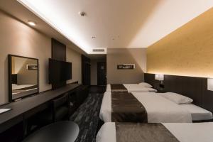 a hotel room with two beds and a flat screen tv at KKR Hotel Osaka in Osaka