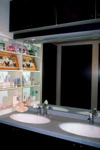 uma casa de banho com 2 lavatórios e um espelho grande em Nakagawa's Cozy House em Sakai