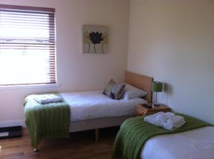 a bedroom with two beds and a window at Ashbank Bed & Breakfast in Drymen