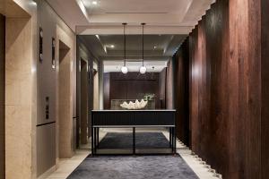 a hallway with a black console table in a room at Quay West Suites Melbourne in Melbourne