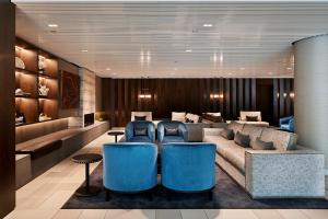 a lobby with a couch and blue chairs at Quay West Suites Melbourne in Melbourne