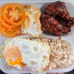 a plate of food with eggs and rice and tomatoes at Prince Transient house in San Jose