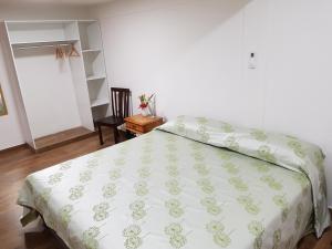 a bedroom with a bed with a green and white comforter at Gamboa Apartment Toucan y Studio Ñeque in Gamboa