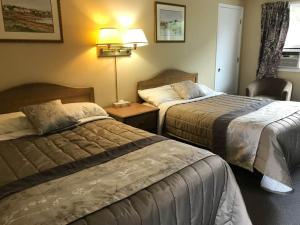 a hotel room with two beds and a lamp at Coastal Inn Digby in Digby