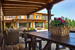 - une table en bois avec des fleurs sur la terrasse dans l'établissement Hospedaje Granada, à San Vicente de la Barquera