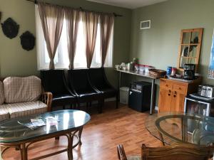 a living room with black leather chairs and a table at Cardinal Court Motel in Saint Thomas