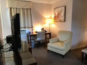 a hotel room with a television and a chair and a desk at Cardinal Court Motel in Saint Thomas