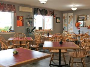 a dining room with wooden tables and chairs at Coastal Inn - Kingfisher in Digby