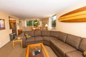 uma sala de estar com um sofá e uma prancha de surf na parede em Royal Kahana 220 em Lahaina