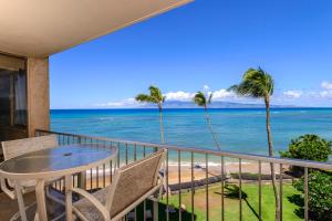 a balcony with a table and chairs and the ocean at Royal Kahana 409 in Lahaina