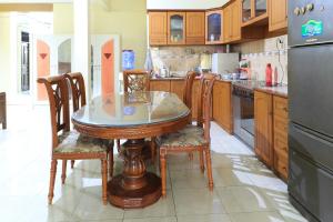 eine Küche mit einem Tisch und Stühlen sowie einem Kühlschrank in der Unterkunft Guest House Samarinda in Samarinda