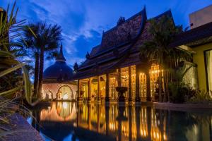 a building with a pool in front of it at night at Sawasdee Village in Kata Beach
