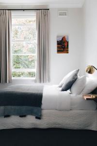 
a bedroom with a white bedspread and pillows at Naughtons Hotel in Melbourne
