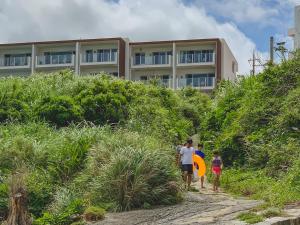 eine Gruppe von Menschen, die vor einem Gebäude einen Hügel hinaufgehen in der Unterkunft Hideout Okinawa Uruma in Uruma