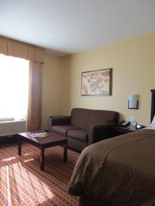 a hotel room with a bed and a couch at Poplar Tree Inn in Stoughton