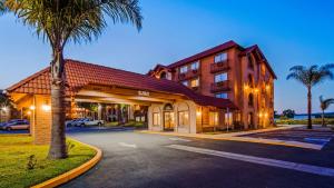 a building with a palm tree next to a street at Lompoc Valley Inn and Suites in Lompoc