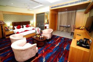 une chambre d'hôtel avec un lit et deux chaises dans l'établissement The Landmark Amritsar, à Amritsar