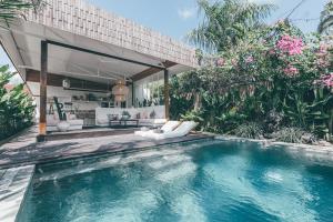 a pool in the backyard of a villa with a house at La Payesa in Canggu