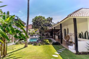 a backyard with a pool and a house at La Payesa in Canggu