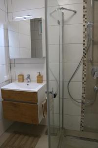 a bathroom with a sink and a shower with a mirror at Stadl-Ferienwohnung in Sankt Georgen am Längsee