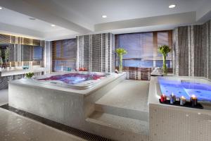 a large bathroom with a tub and a large window at Somerset Heping Shenyang in Shenyang
