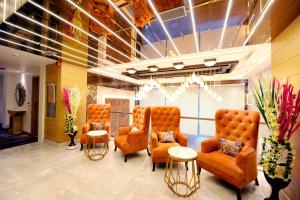 a waiting room with orange chairs and tables at Hotel Landmark Near Golden Temple in Amritsar
