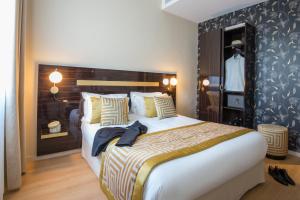 a bedroom with a large bed and a mannequin in a mirror at Hotel Carlton in Beaulieu-sur-Mer